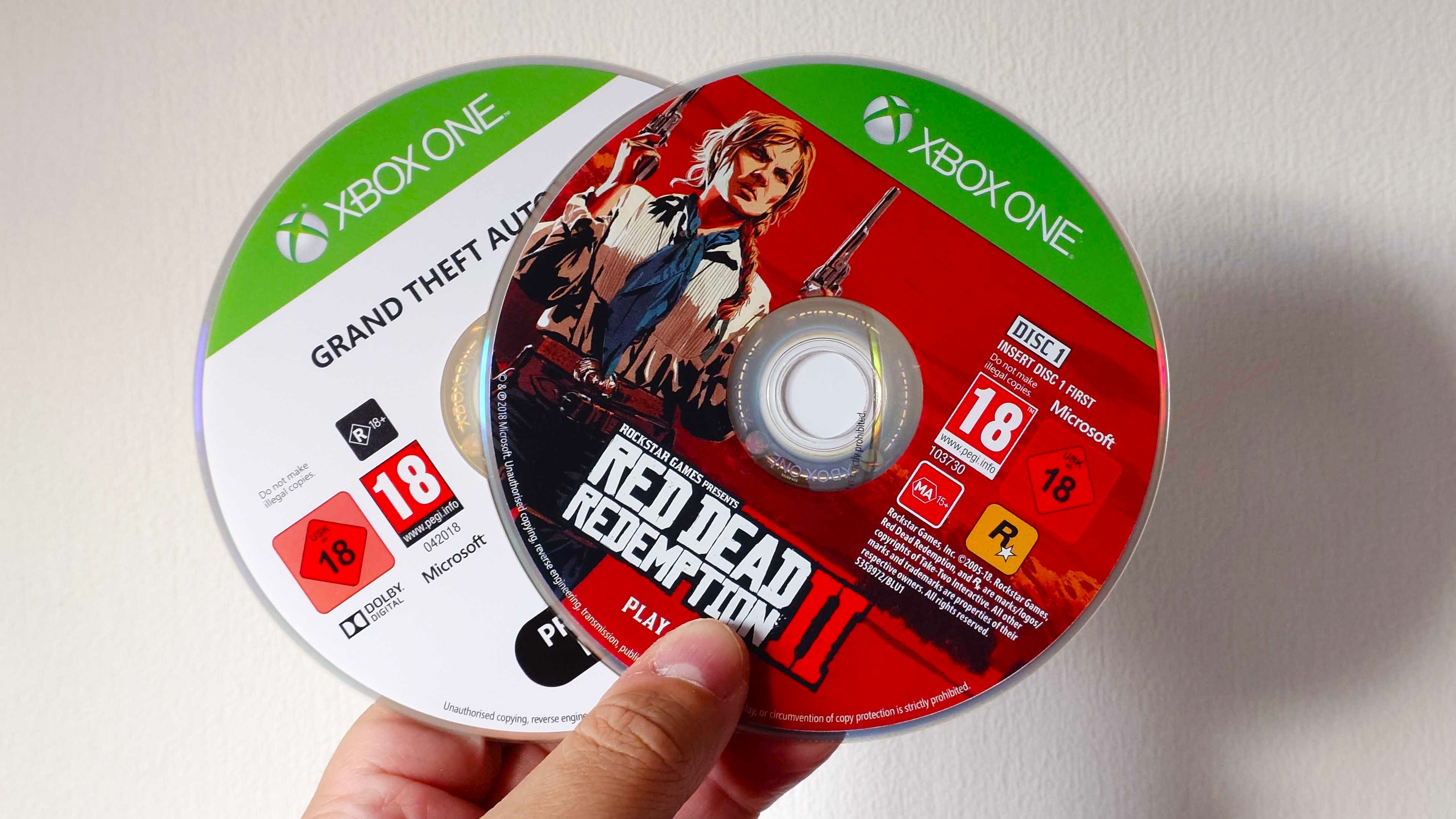 A photo of Xbox One game discs for Rockstar Games' Red Dead Redemption 2 and GTA 5. 
