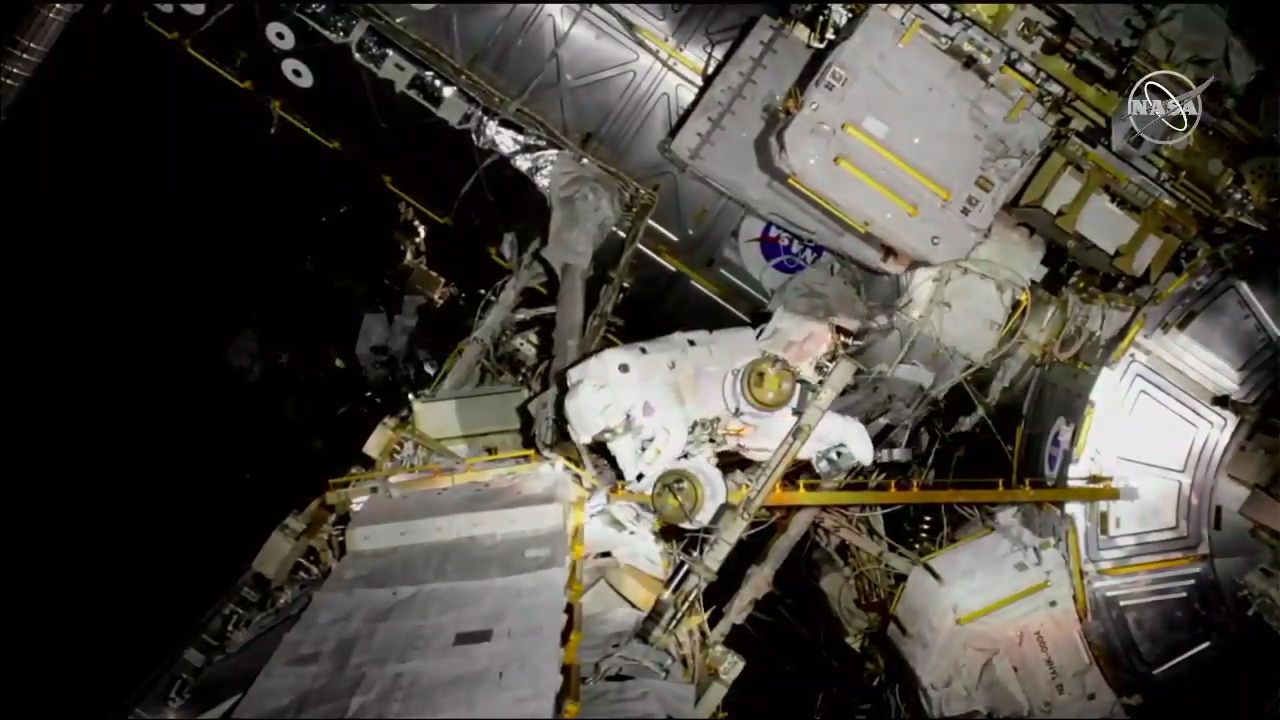 NASA astronaut Nick Hague heads over to assist McClain after her tether gets caught on something.