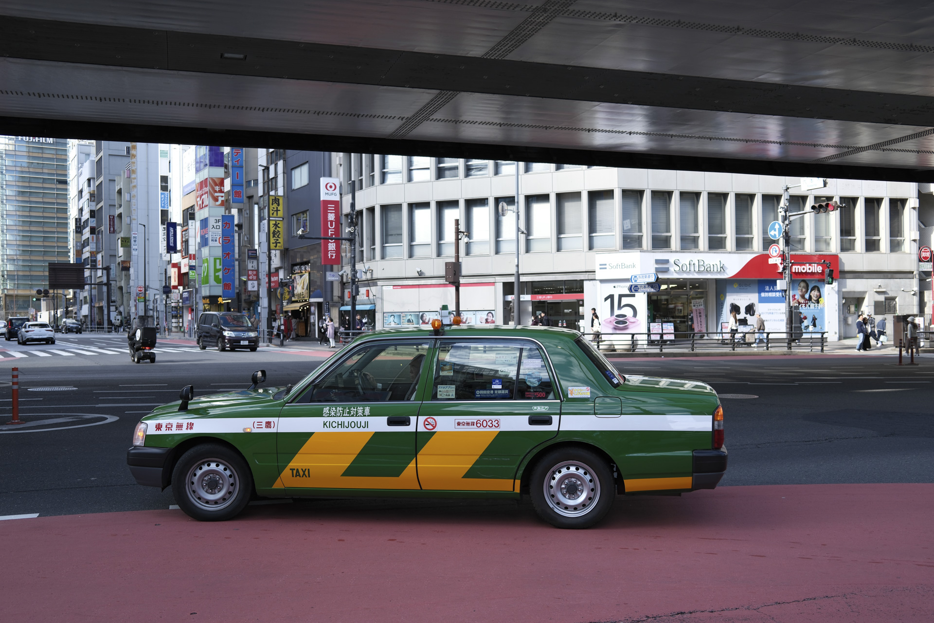 Street photo in Tokyo of a green taxi