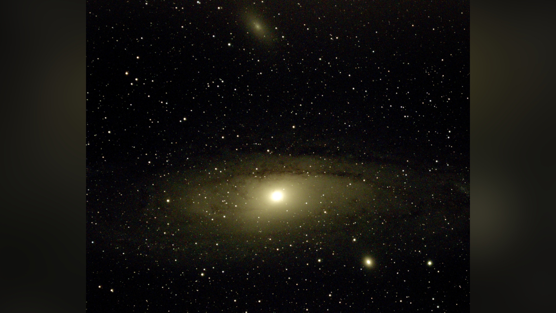 the andromeda galaxy appears as a bright ball of light surrounded by gas and dust revealing a subtle spiral shape.