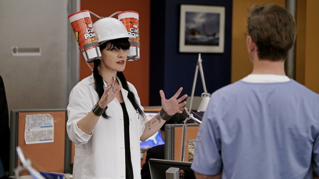 Abby Sciuto wearing a helmet with two cups of Caf-Pow attached to the sides in NCIS