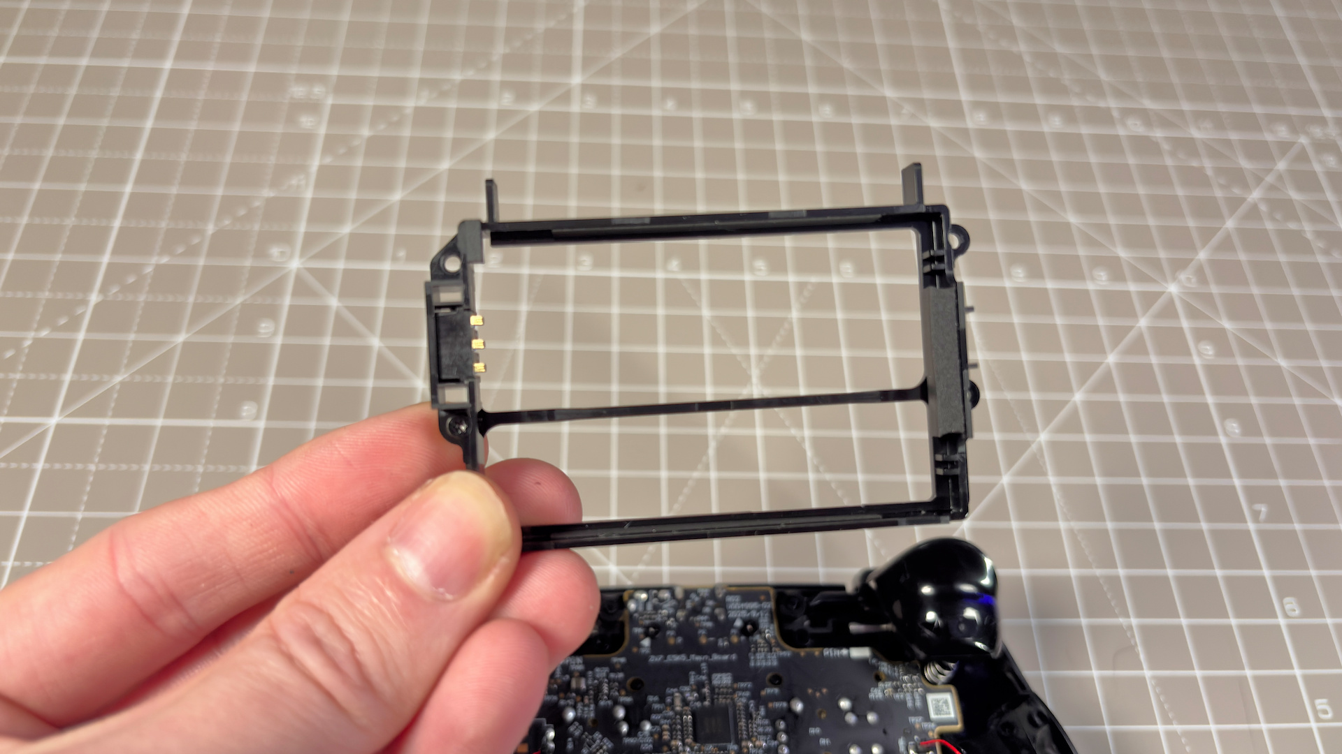 The Steam Controller on a desk during a teardown, with various parts removed.