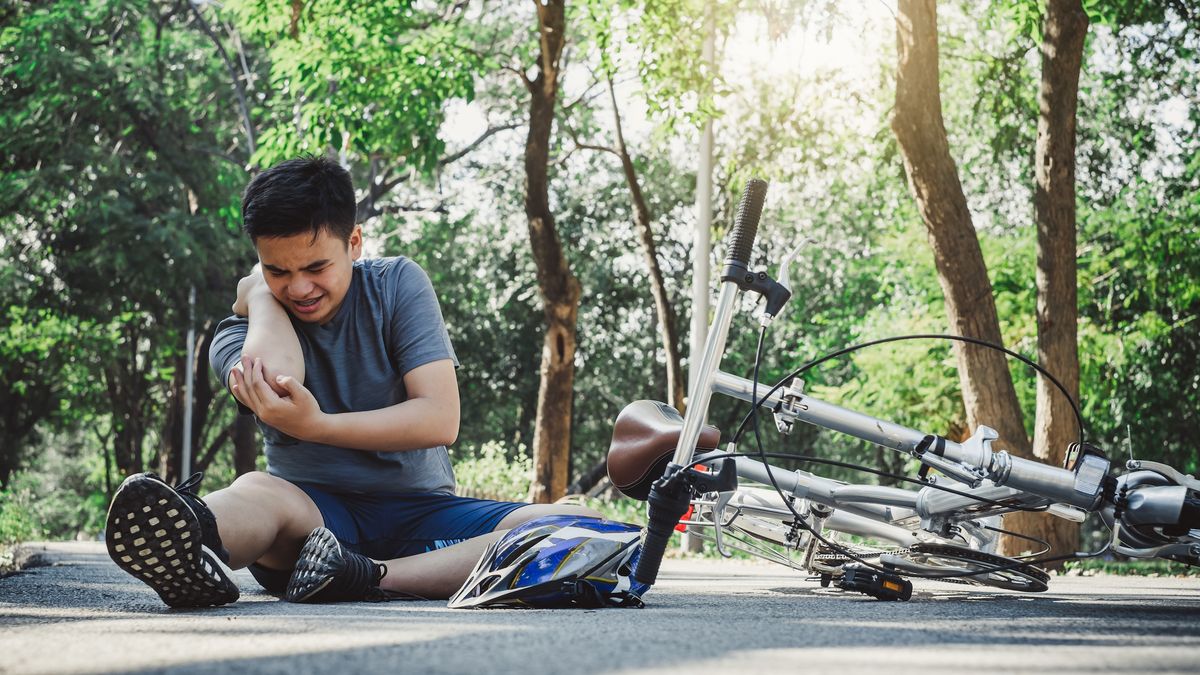 A man holds his hurt elbow after a bike accident