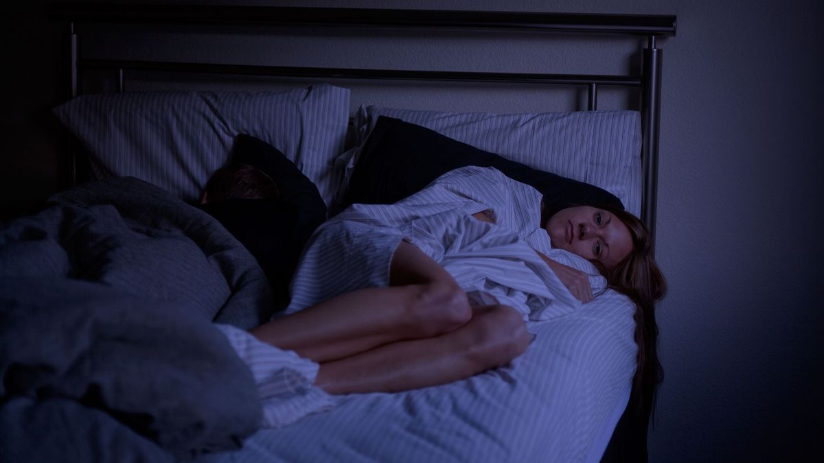 A woman lying awake in bed at night