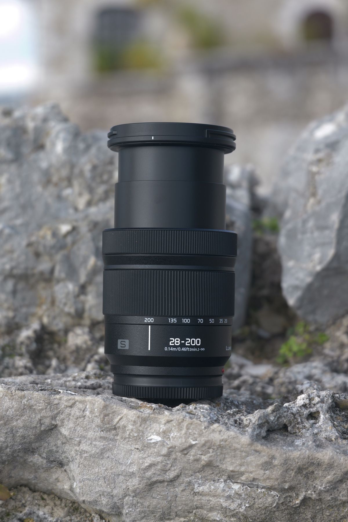 Panasonic Lumix S 28-200mm lens sitting on a rock