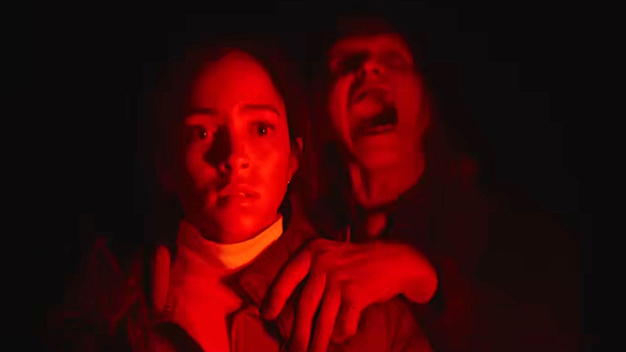 Lou Lloubell as Maddie stands in red light with the Passenger (Joseph Lopez) grabbing her shoulder in the trailer for Passenger.