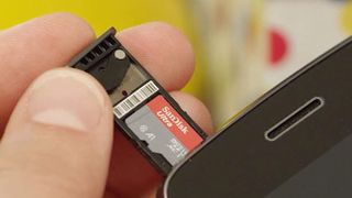 Sandisk ultra microsd içeren bir tepsi tutan bir kişi