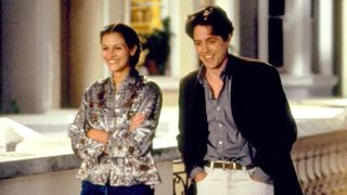 Julia Roberts and Hugh Grant smilling and walking through a street in london in 'Notting Hill.'