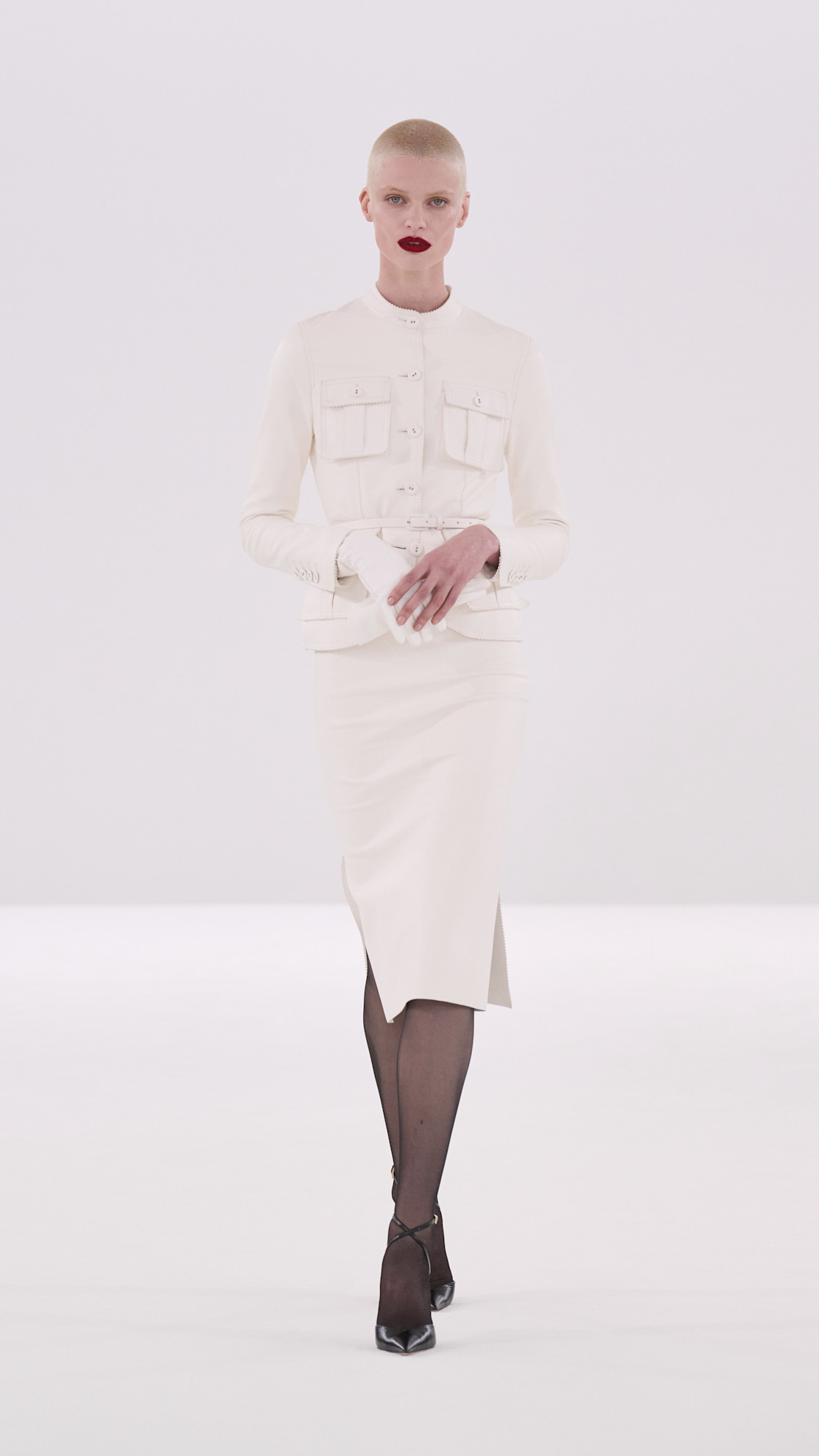 A model walking in the Tom Ford show during the F/W 2026 show wearing a skirt suit.