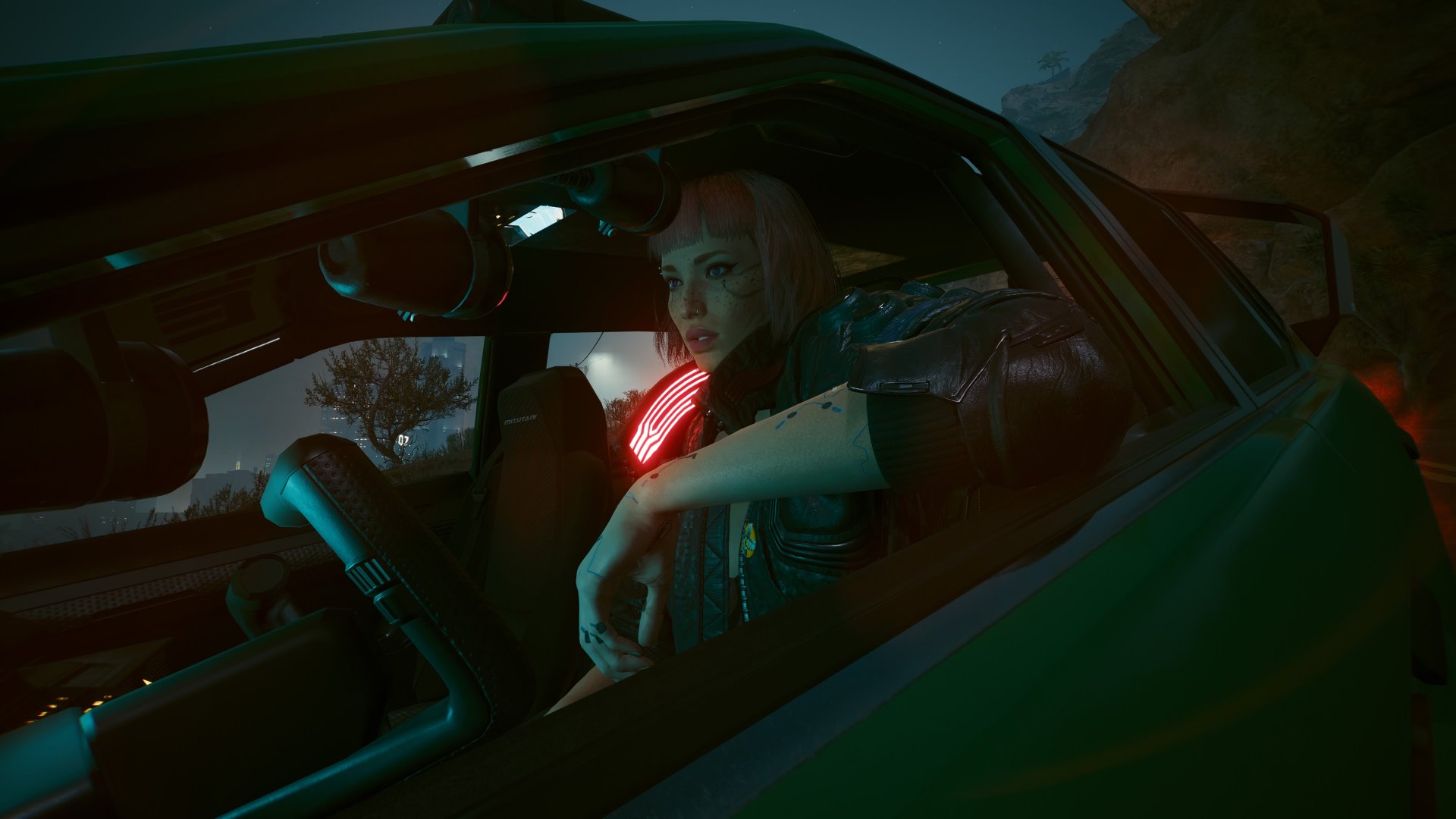 Cyberpunk 2077 2.3 update screenshot of V sitting in a car while auto-drive is on, and their hands aren't touching the steering wheel
