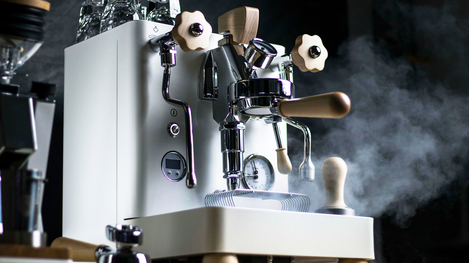 White espresso machine surrounded by a cloud of steam