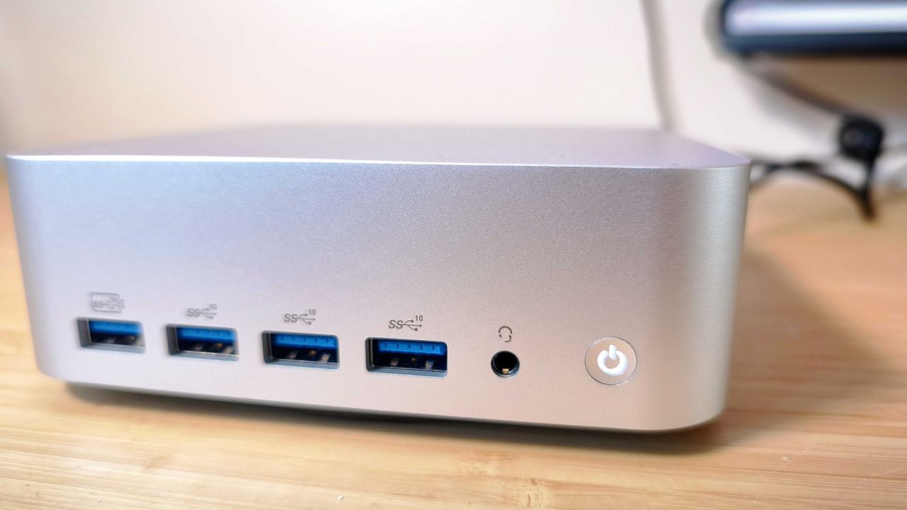 A silver Geekom A9 Max on a wooden desk