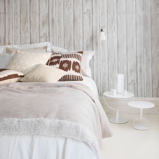 bedroom with grey wooden wall white floor and white bed
