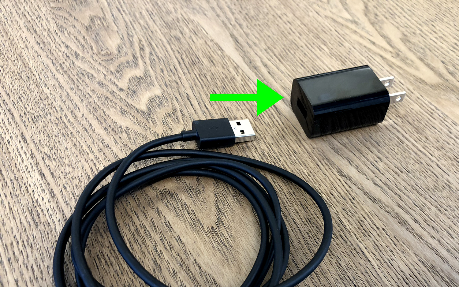 The Fire TV Stick power adapter with a USB cable positioned to be plugging into it