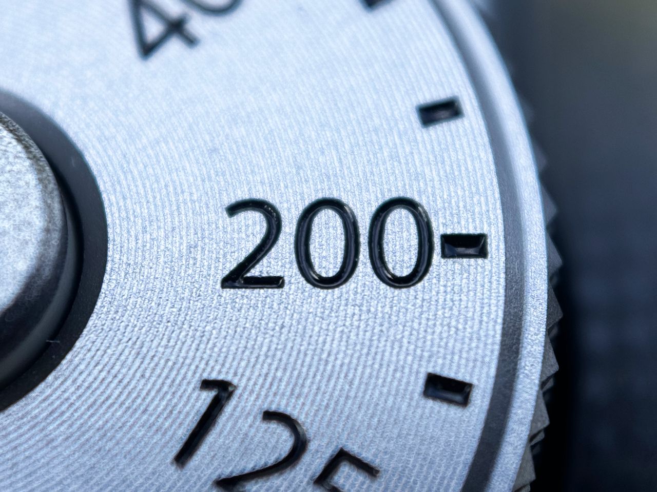 A close up photo of a silver camera dial taken on an iPhone 15 Pro using the Sandmarc macro lens