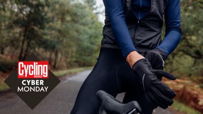 Male cyclist pulling on a pair of winter gloves, with the Cycling Weekly Cyber Monday deals roundal