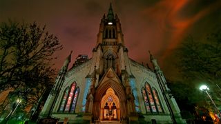 Night time image showing church with reddish sky.