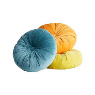 A trio of 3 bright and colorful round velvet throw cushions in turquoise, lime green, and yellow
