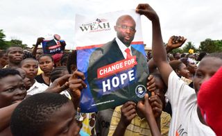 Young Liberians hold up a George Weah postet ahead of presidential elections in the country in 2017.