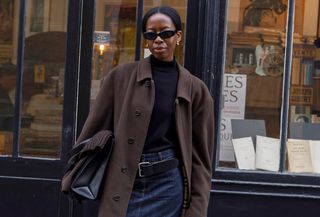 French influencer wearing black turleneck sweater, denim midi skirt, brown coats, tights, and black heeled mules.