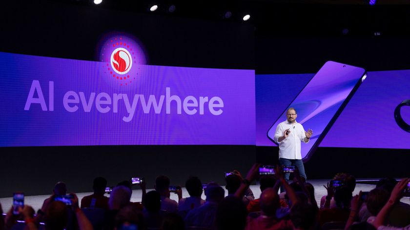 Cristiano Amon on stage with &quot;AI everywhere&quot; behind him