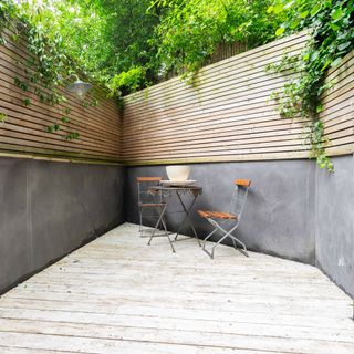 garden grey wall wooden fencing table and chairs