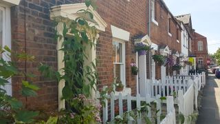 row of Victorian terrace houses with white picket fences