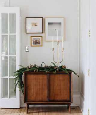 hallway with wood cabinet with Christmas garland and gold candle holder