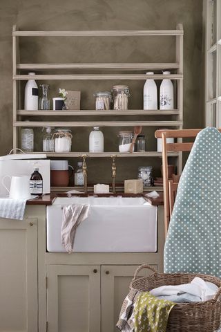 warm grey laundry room with freestanding shelving