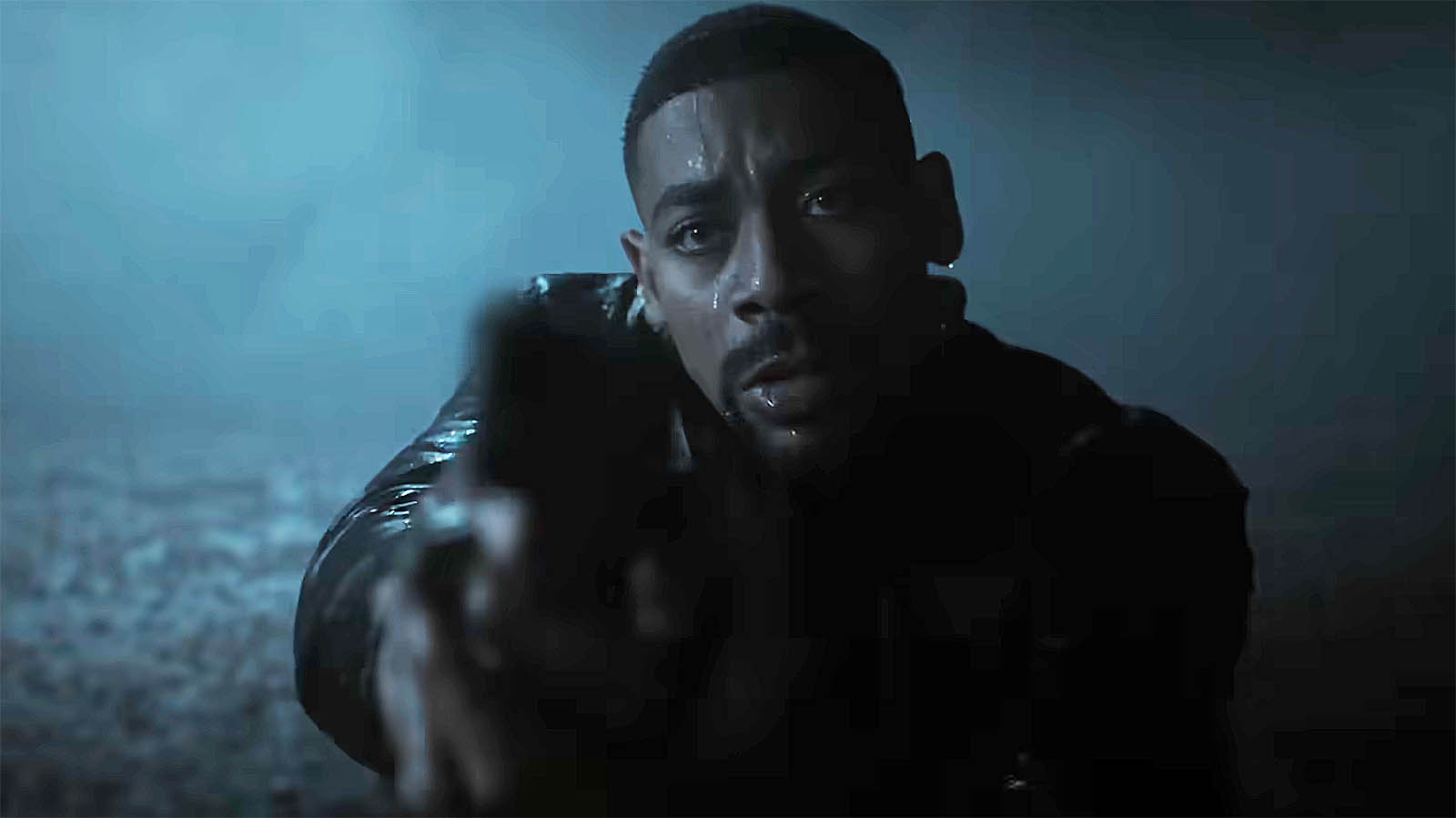 John Stewart holding a handgun while sitting in a canoe in a storm at night in Lanterns episode 7