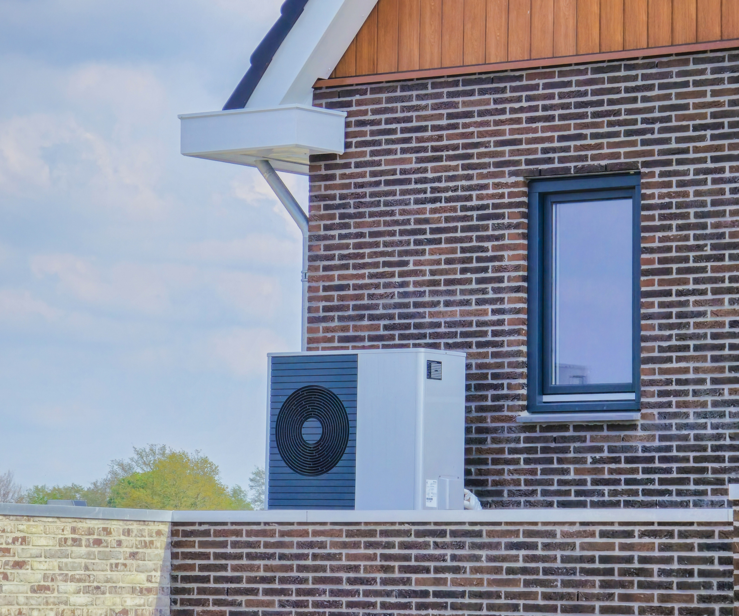 heat pump installed at high level outside brick home