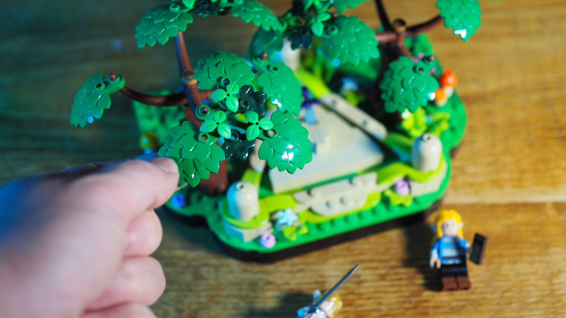 A hand places a leaf on the Lego Great Deku Tree Master Sword Shrine