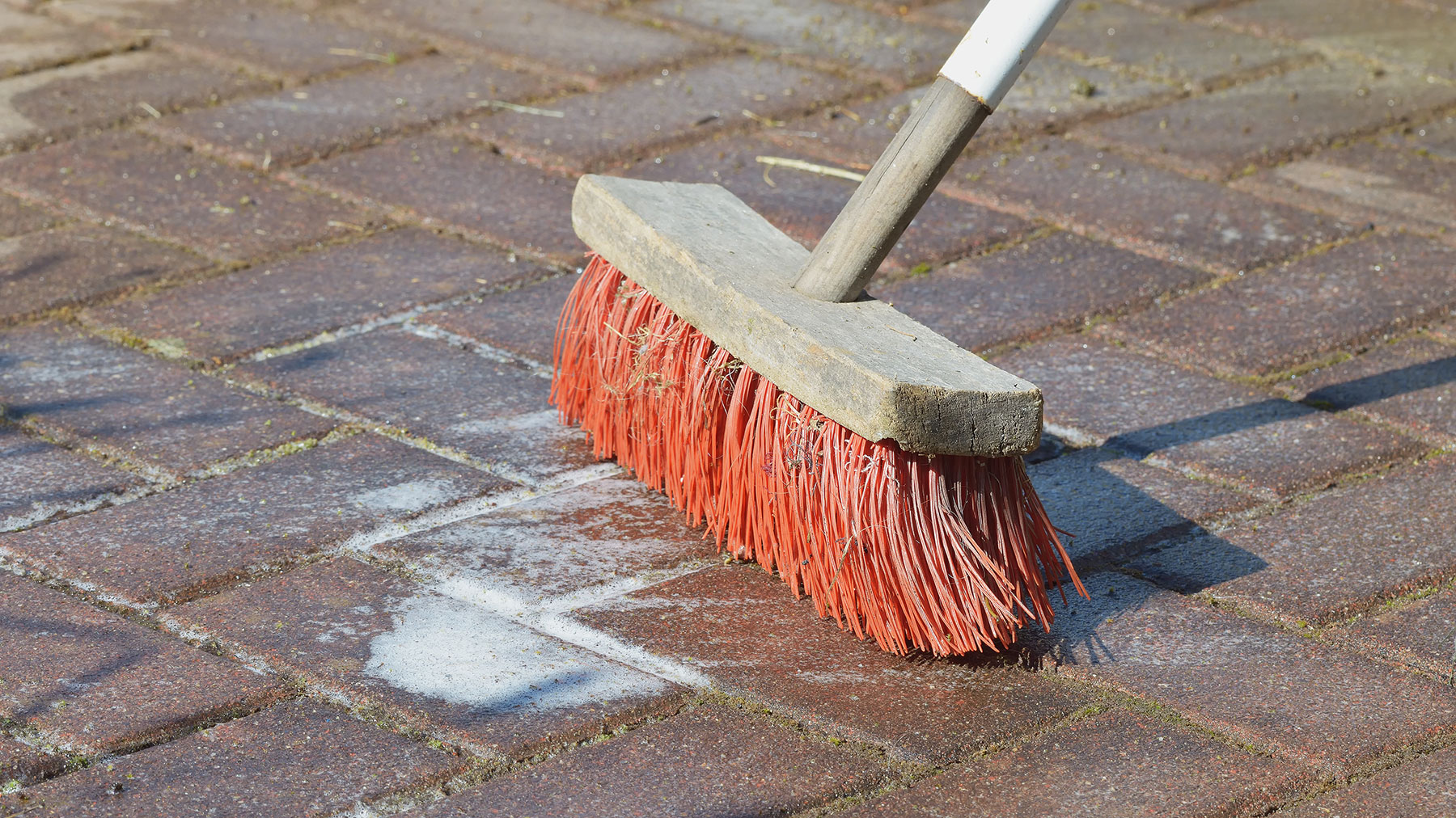 Cleaning a patio with water and a broom