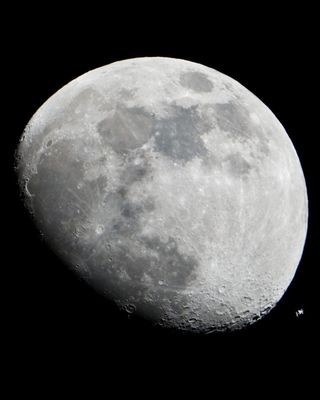 The International Space Station can be seen as a small object in lower right of this image of the moon in the early evening Jan. 4 in the skies over the Houston area flying at an altitude of 390.8 kilometers (242.8 miles).