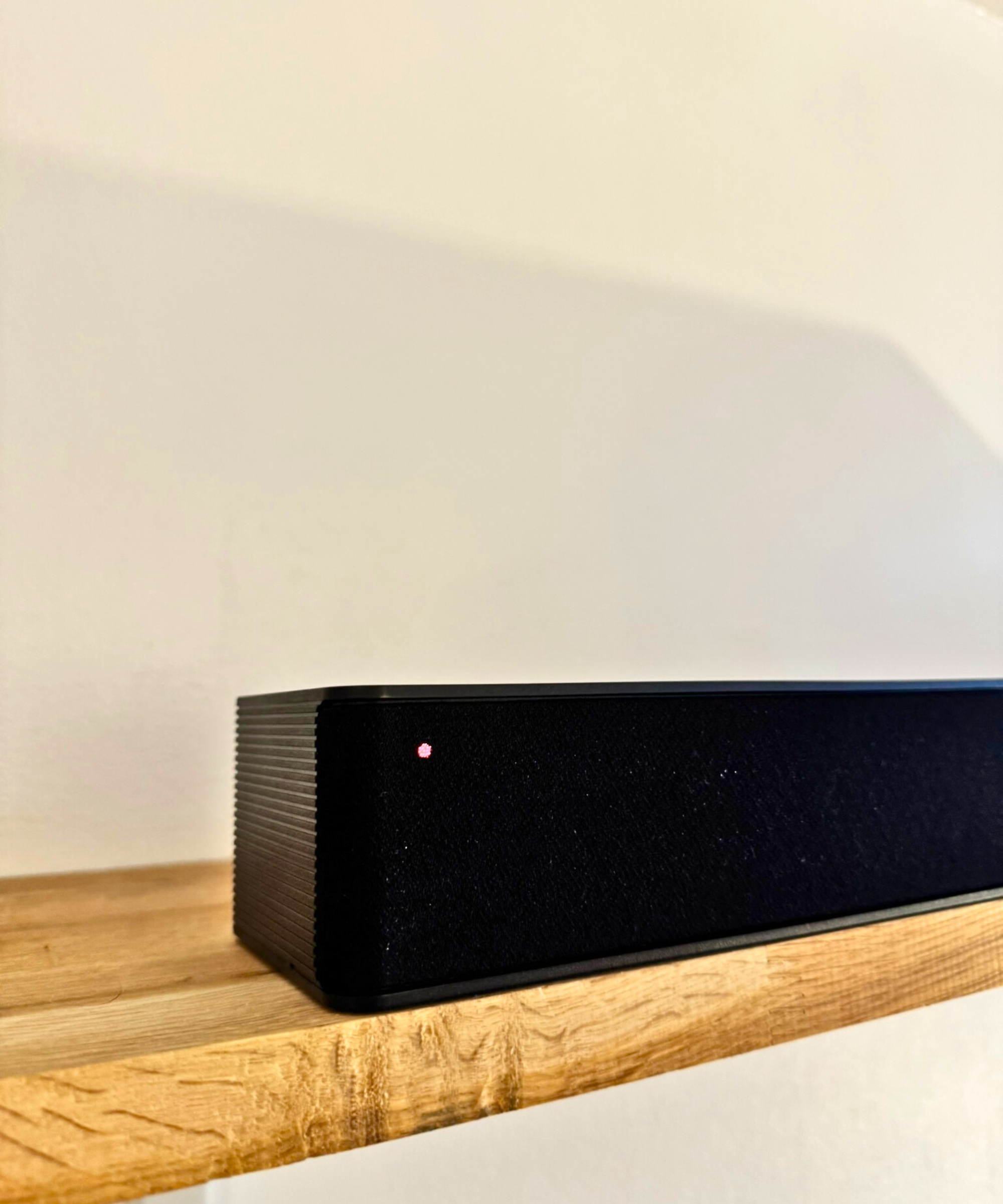 Closeup of Hisense HS2100 soundbar on wooden shelf.