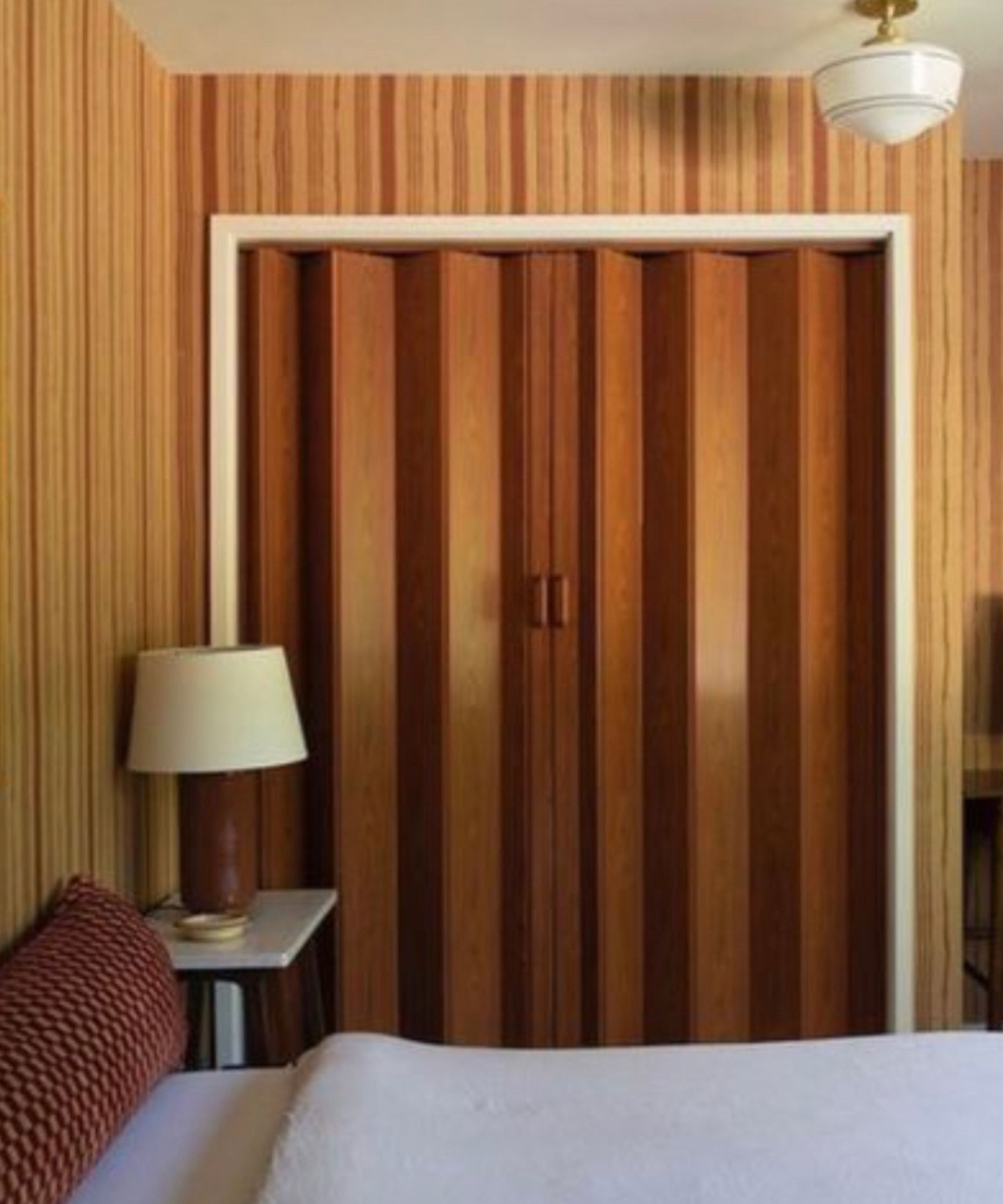 orange mid century bedroom with striped wallpaper