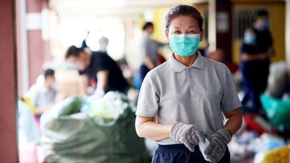 Senior woman volunteering wearing a health mask looking at the camera