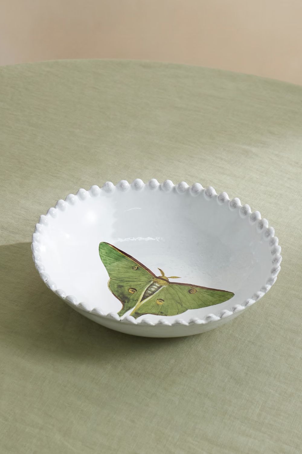 White bowl with green butterfly motif and beaded rim