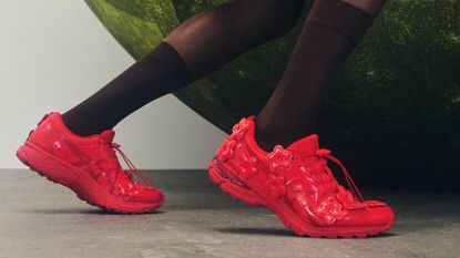 a woman wearing red asics sneakers with black tights