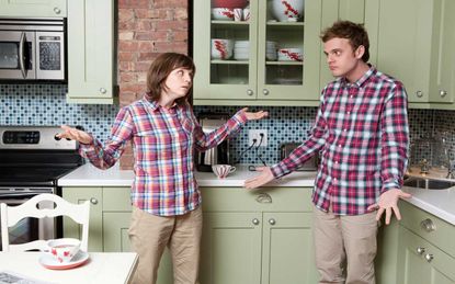picture of couple in their kitchen shrugging their shoulders