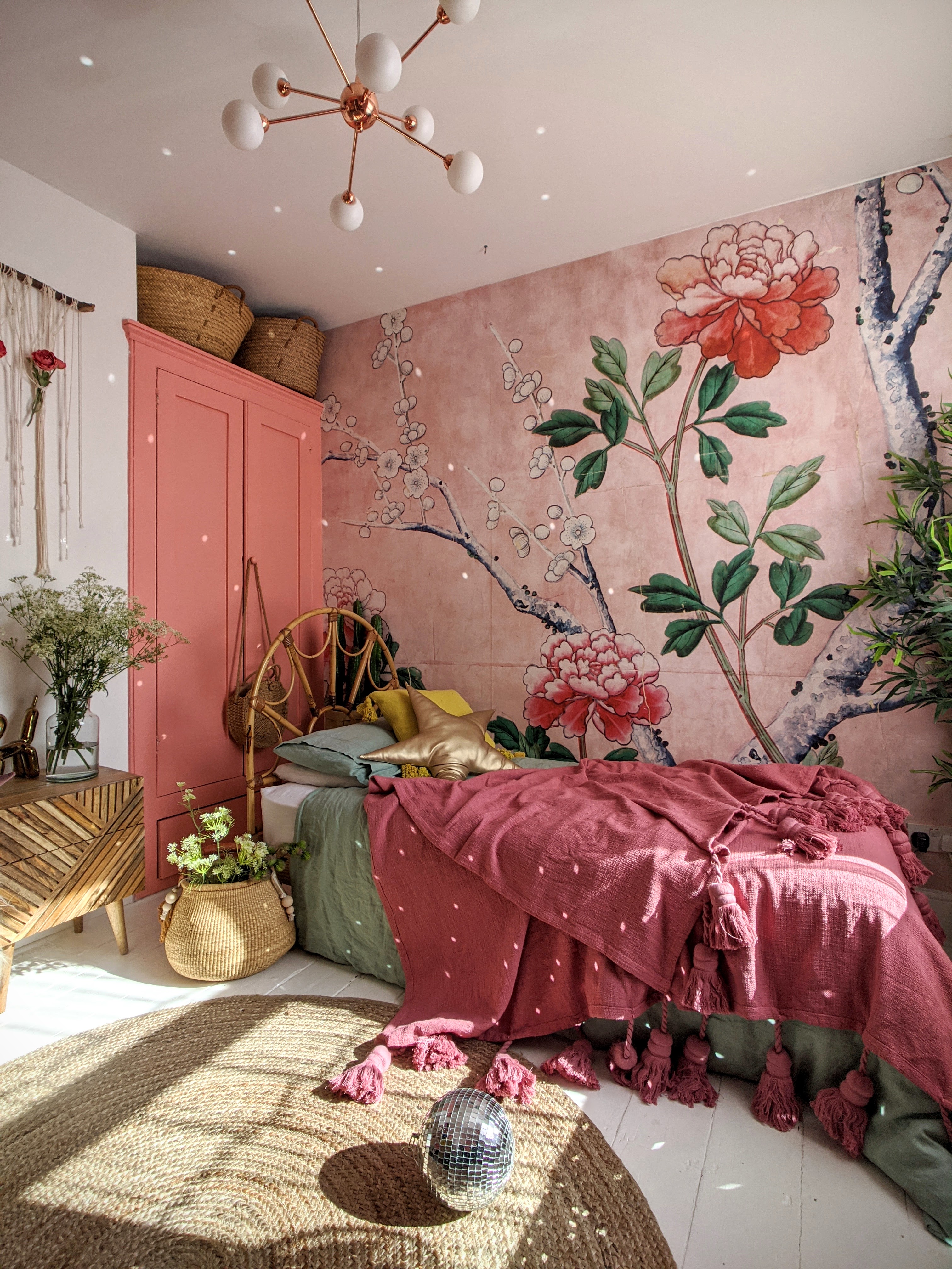 Pink floral wall mural in bedroom with jute rug, modern pendant lighting and pink throw