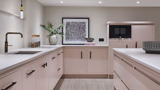 Narrow kitchen with pink cabinets and matt black taps and cabinet handles: showing how to organize a small kitchen with a good flow