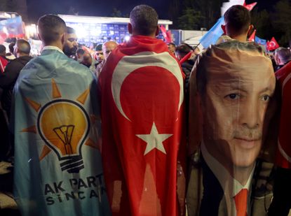 Turkish voters wear flags of the AK Party and showing Erdogan's face