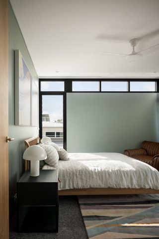 A bedroom with a long rug and space under the bed