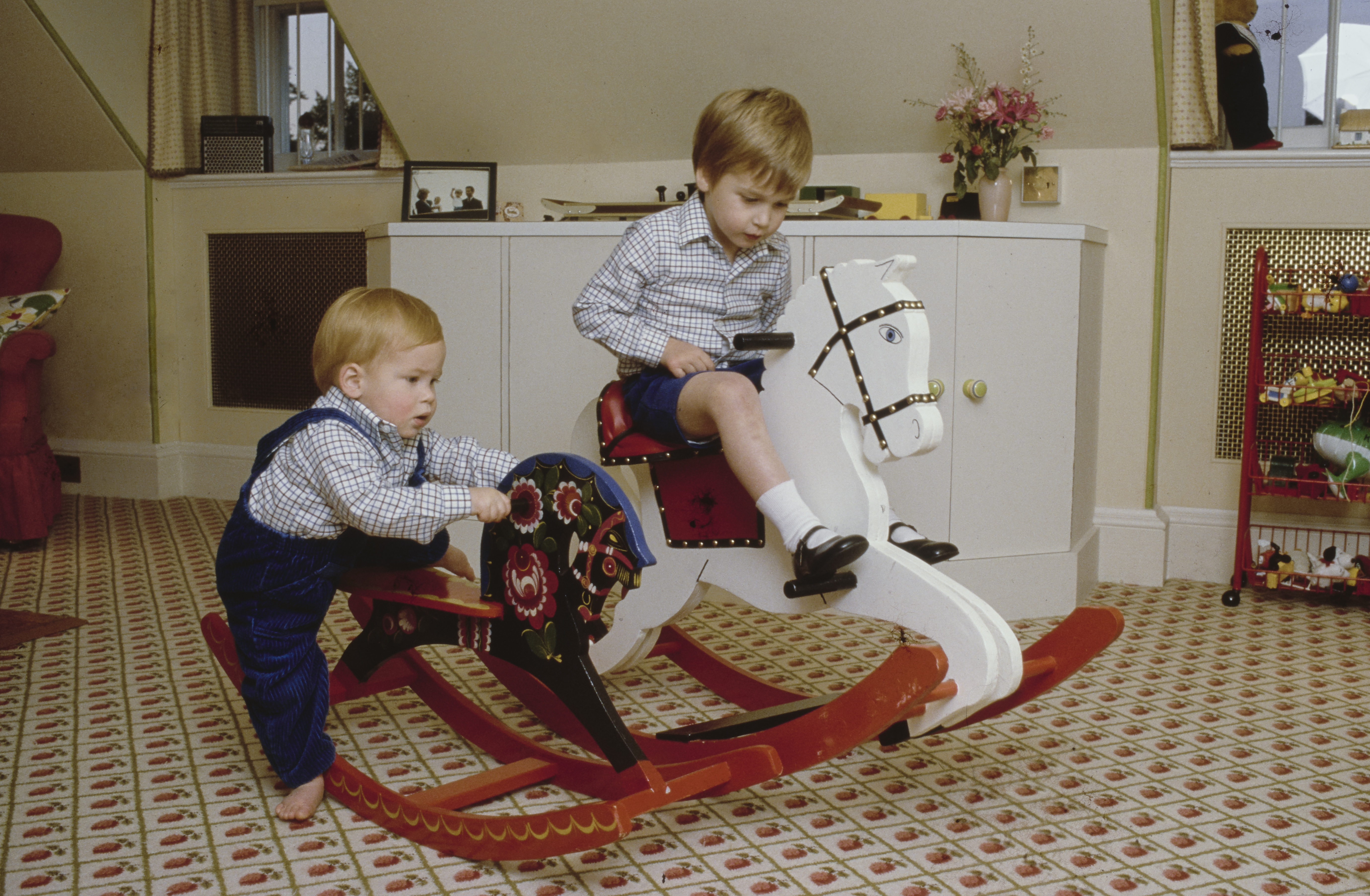 Prince William and Prince Harry riding on rocking horses
