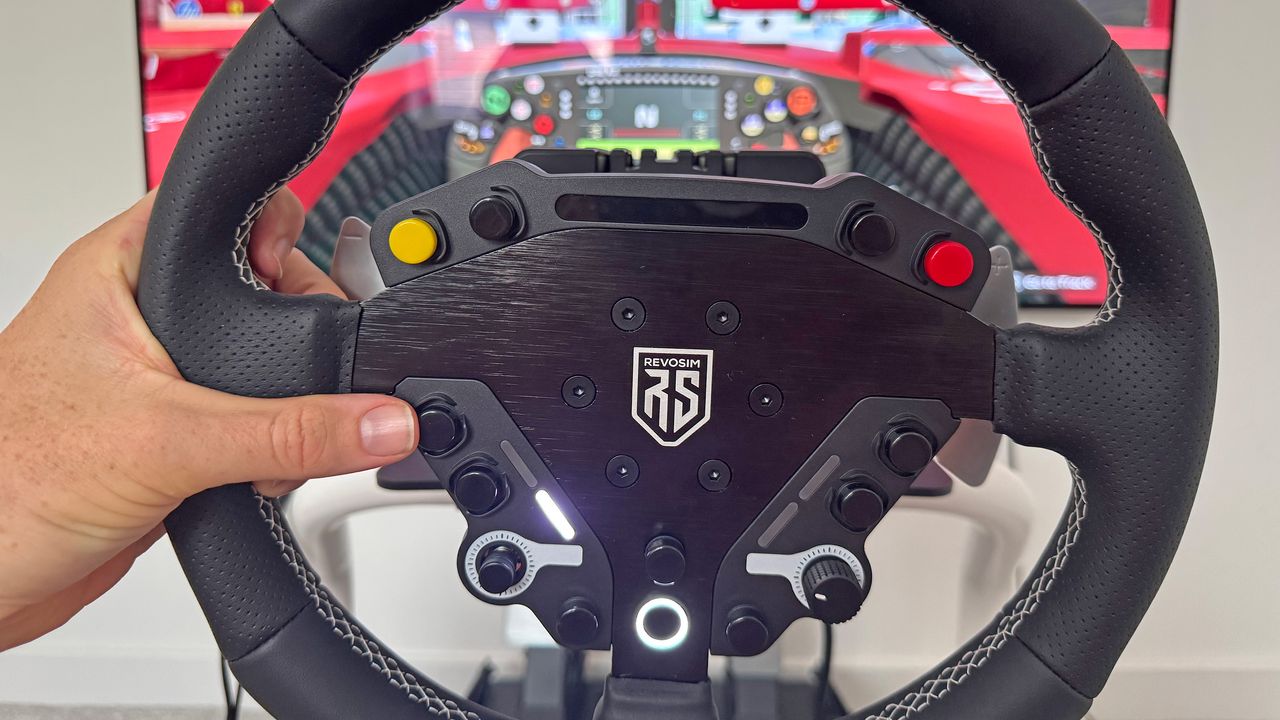 A reviewer holding the Revosim RS steering wheel