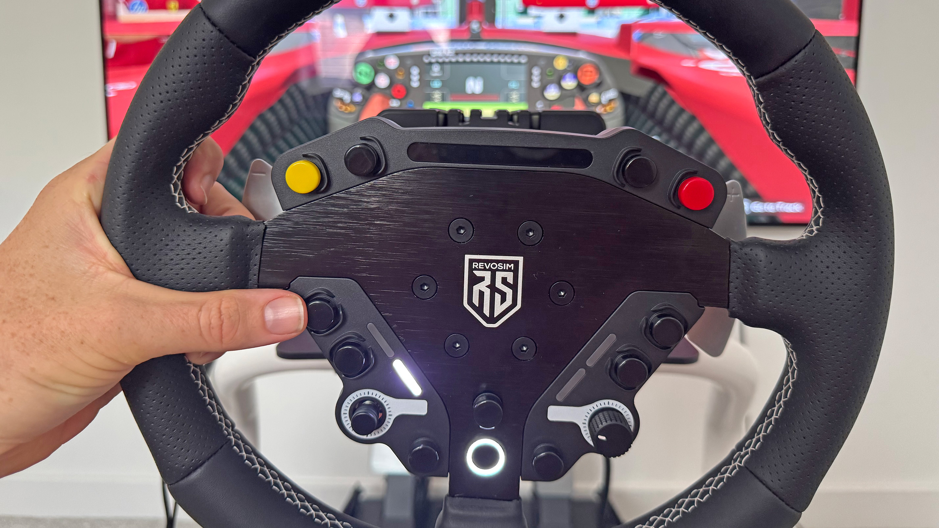 A reviewer holding the Revosim RS steering wheel
