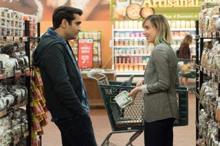 a couple (kumail nanjiani and zoe kazan as emily) talk in a grocery store aisle, in the prime video rom-com 'the big sick'