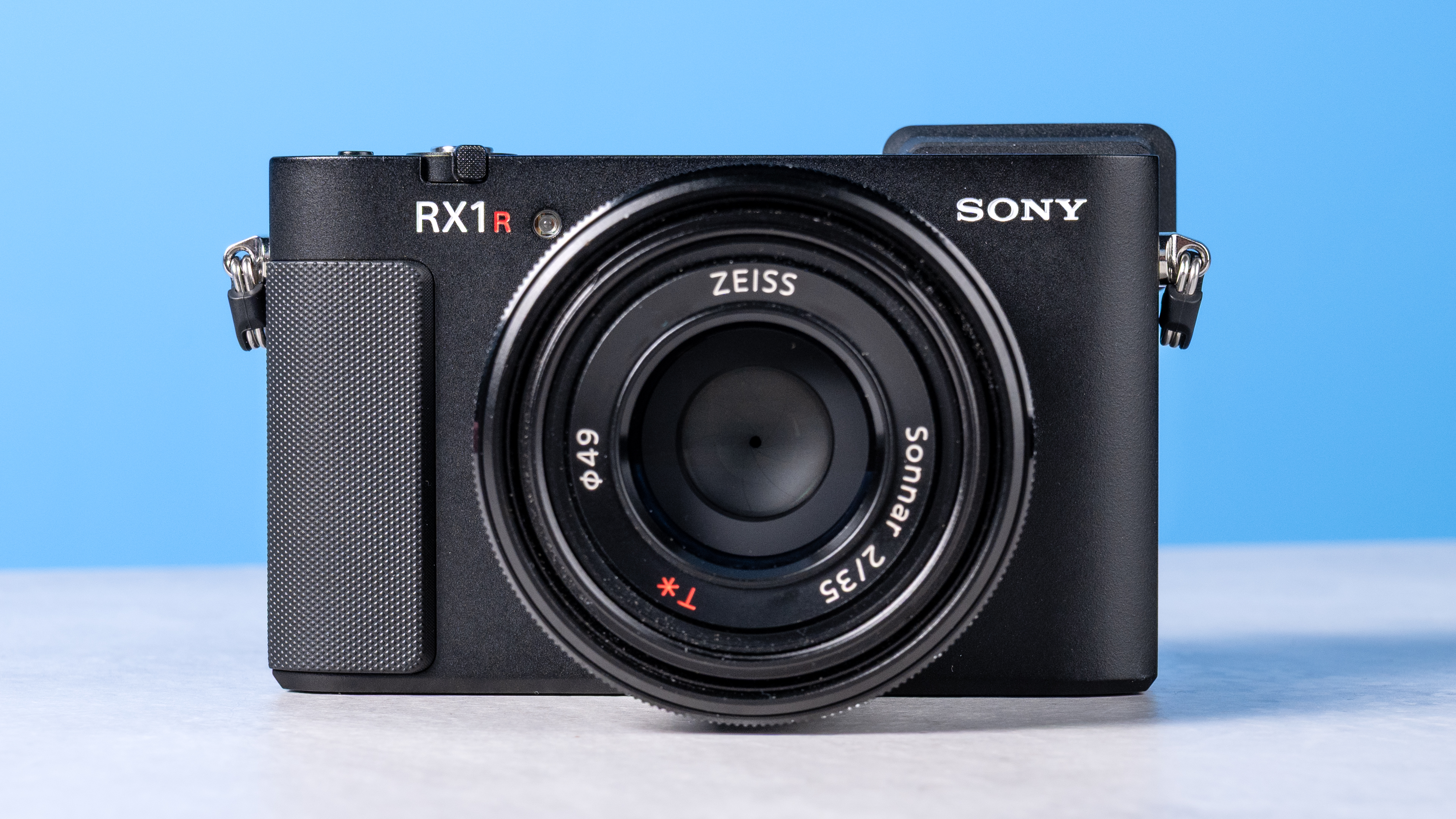 A photo of the Sony RX1R III on a stone surface with a blue background