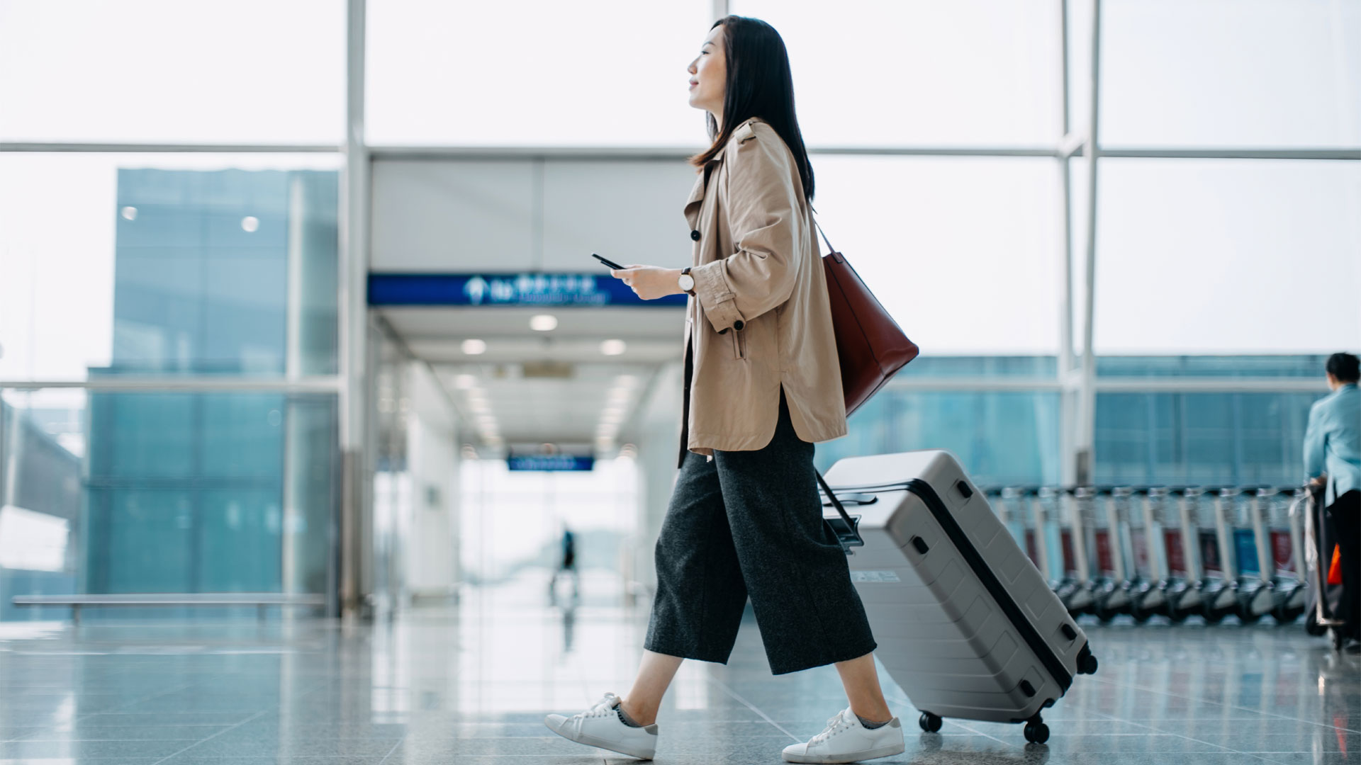 Eine Frau schleppt ihren Koffer durch einen Flughafen